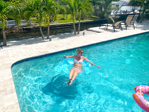 Floating in Tarpon Harbor pool looking out at waterfront river
