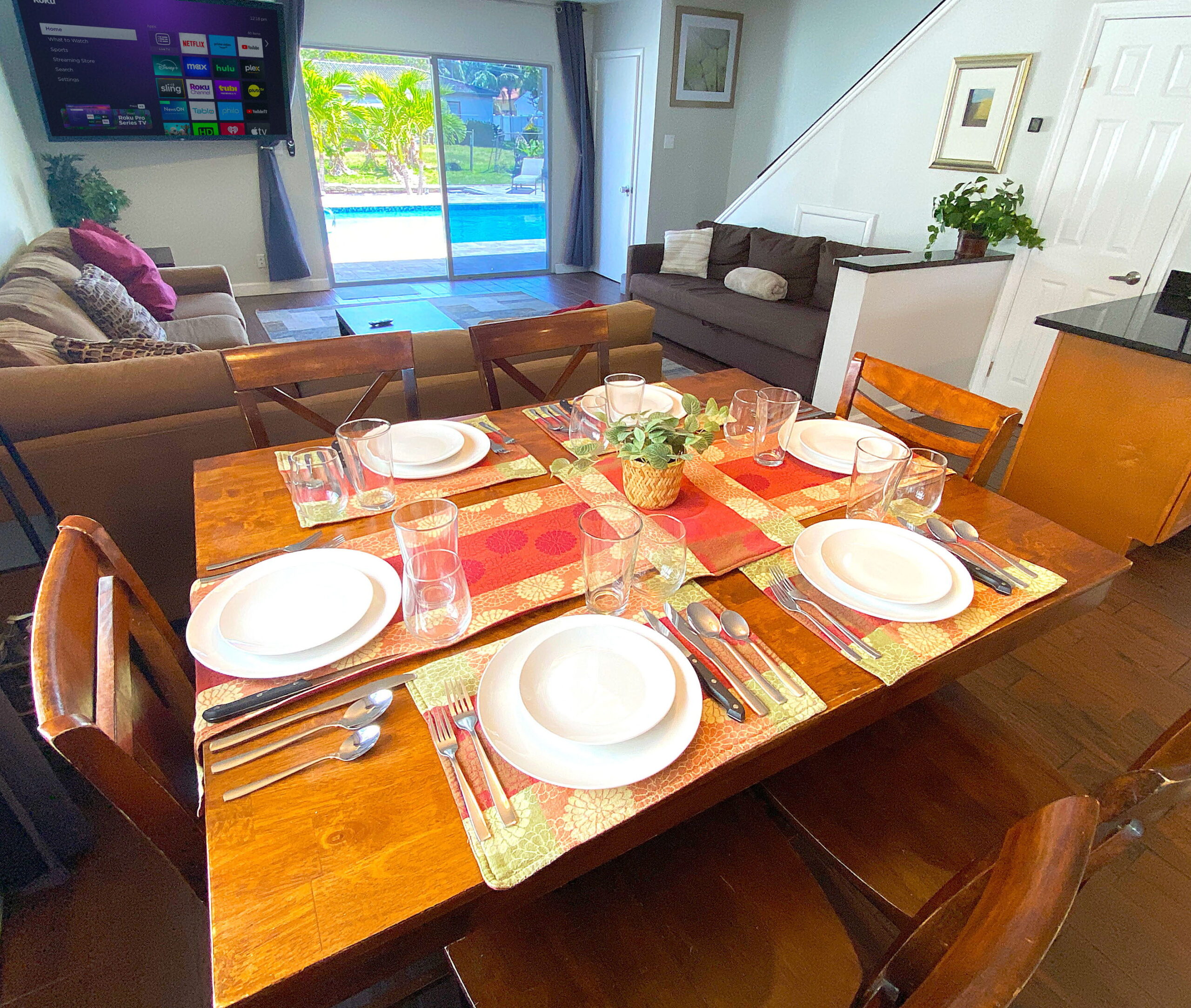 Dining table set for six overlooking the living room and pool at Tarpon Harbor 1