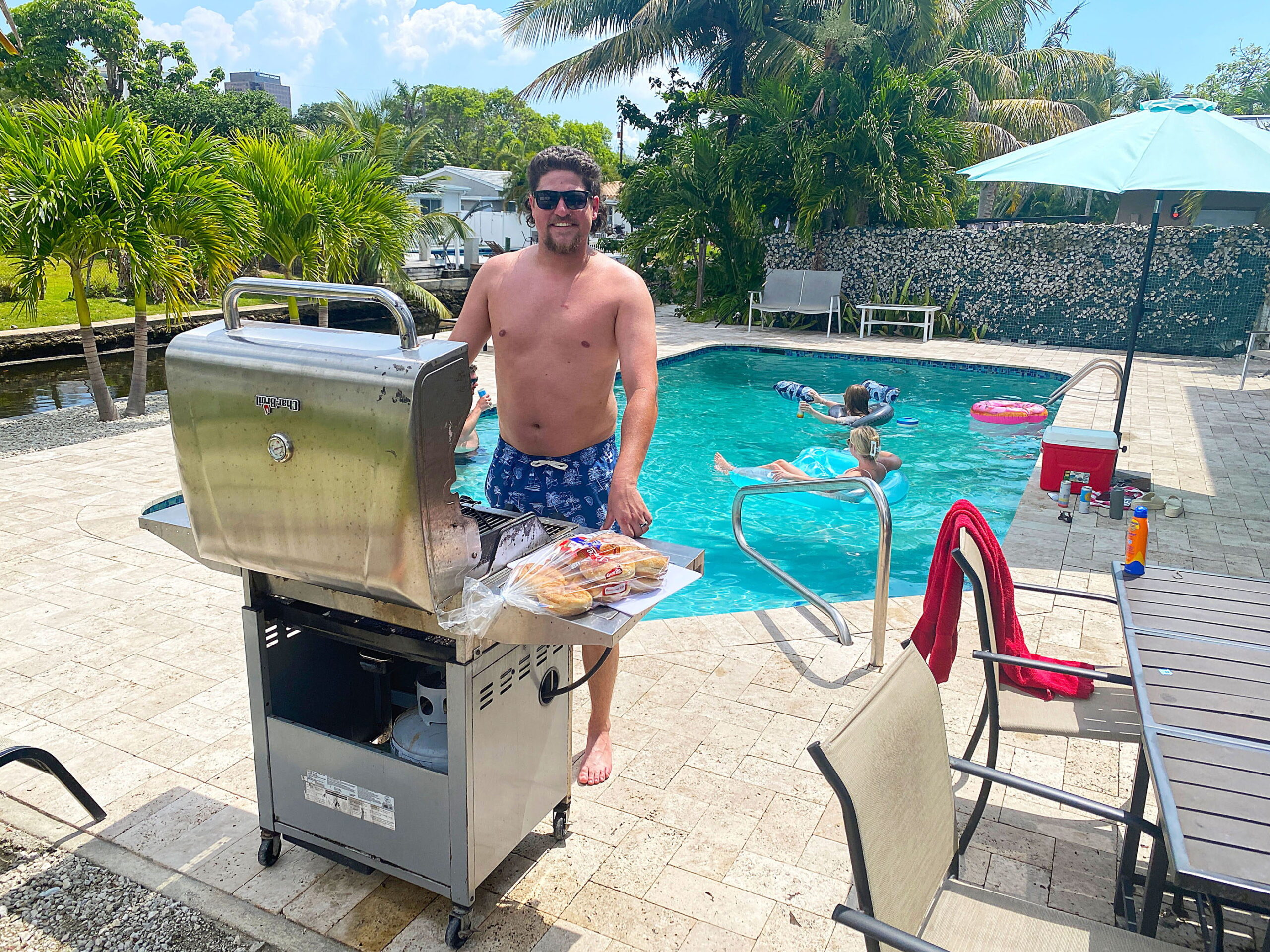 Guest grilling beside the pool at Tarpon Harbor 1 waterfront vacation rental in Fort Lauderdale