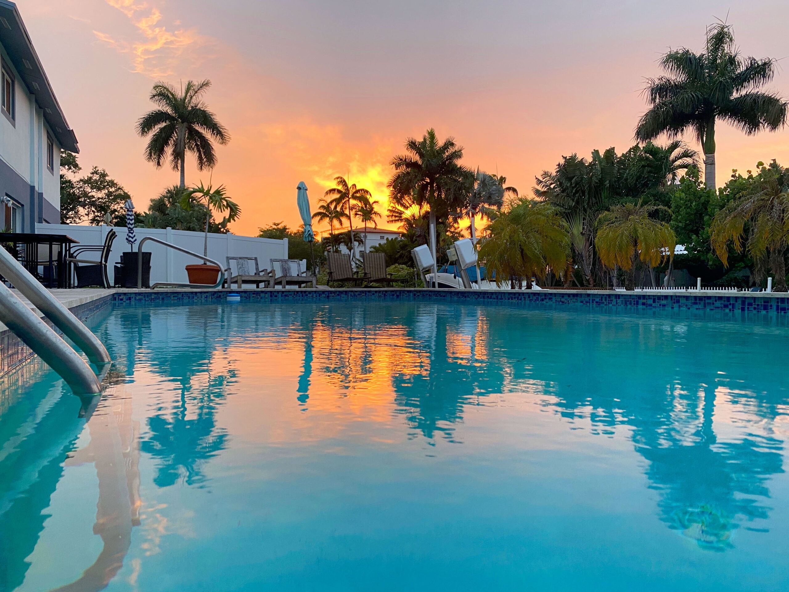 Swimming pool reflecting a colorful sunset at Tarpon Harbor 1 Fort Lauderdale vacation rental